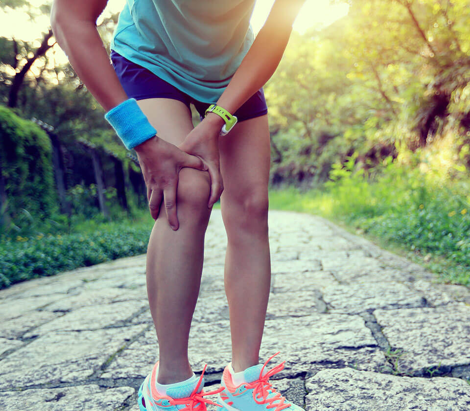 woman holding injured knee